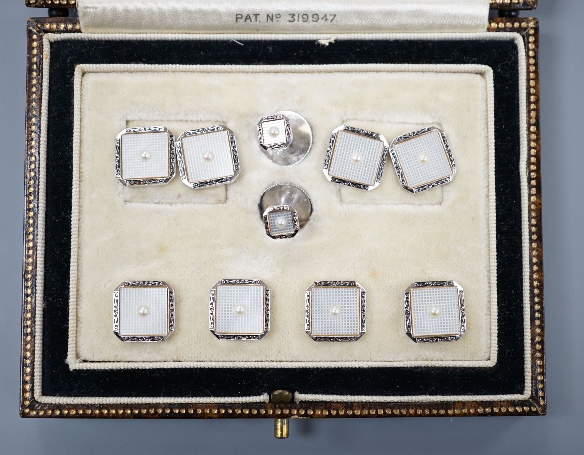 A cased eight piece 9ct white metal and seed pearl set dress stud set, gross 10.8 grams.